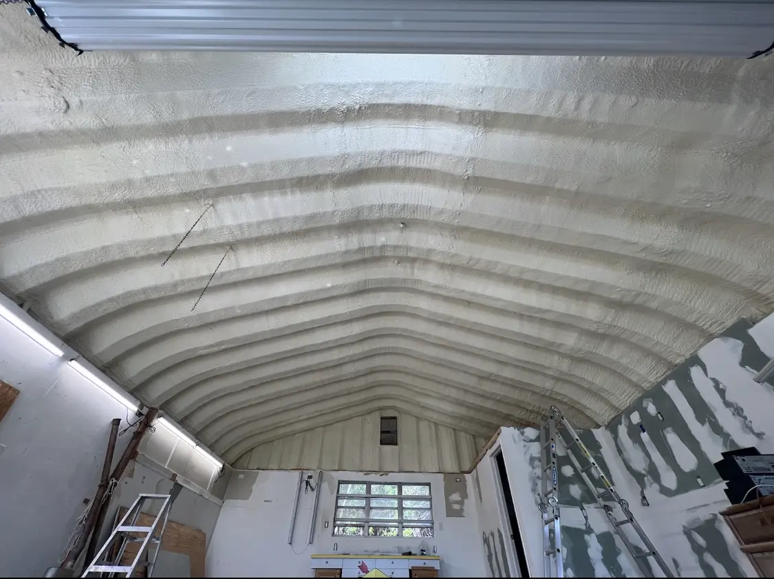 Spray polyurethane foam applied to the underside of a metal roof deck in Cannon